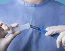 photo of a doctor holding metallic medical scalpel checking circumstance of a patient