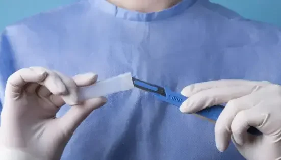 photo of a doctor holding metallic medical scalpel checking circumstance of a patient