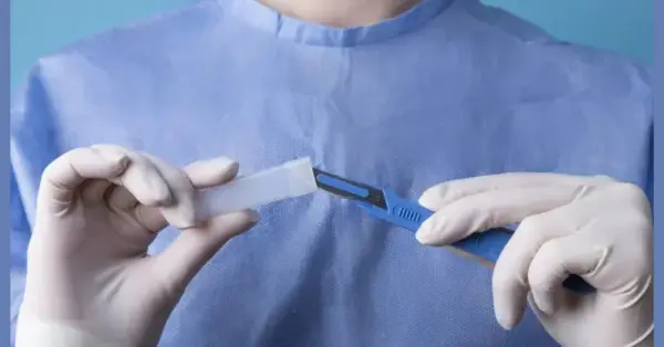 photo of a doctor holding metallic medical scalpel checking circumstance of a patient